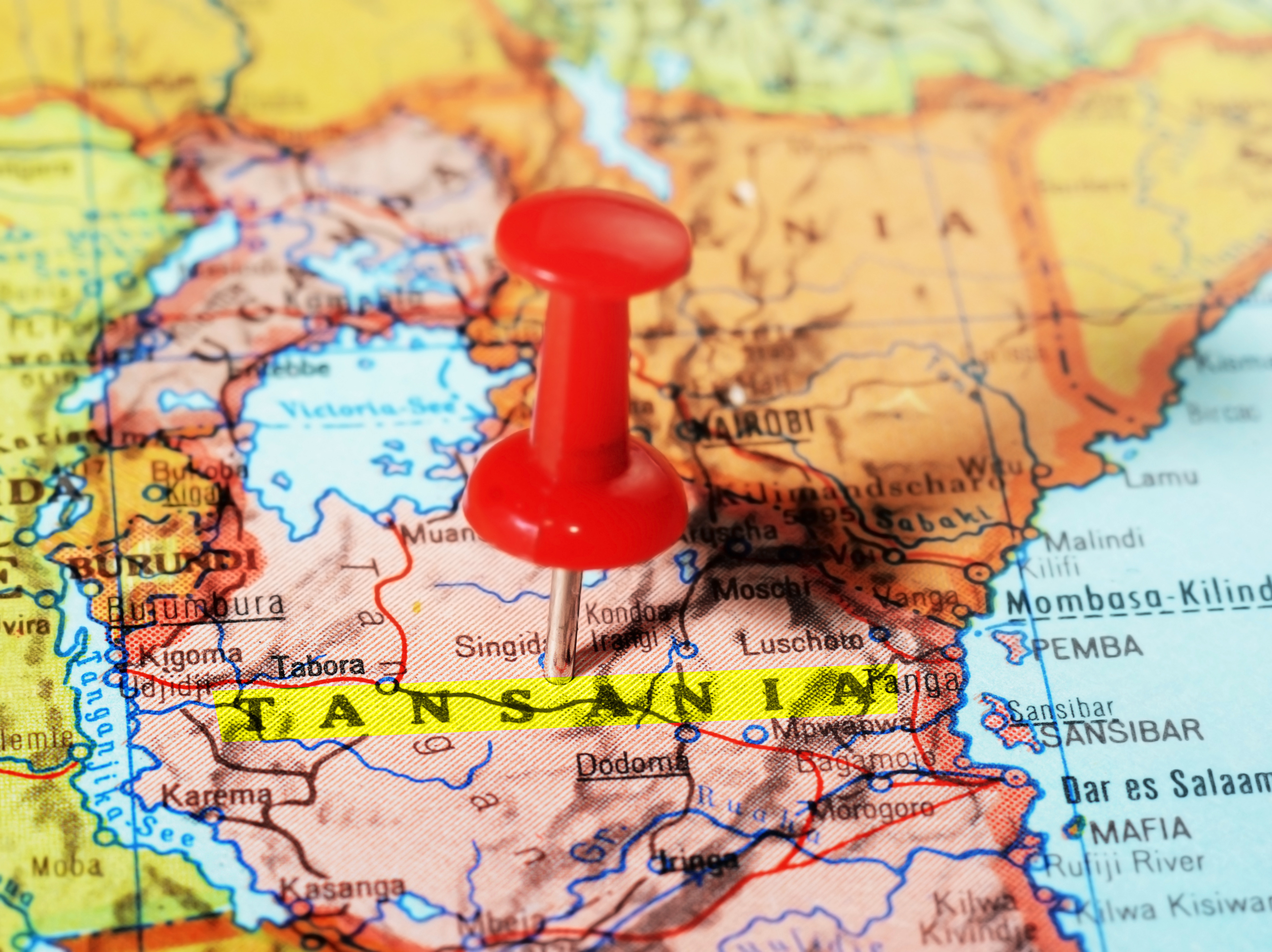 Close-up of a red pushpin on a map of  Tansania  Africa - travel concept